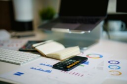 Un titolare di PMI calcola il budget complessivo per social, sito web e video sulla propria scrivania