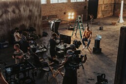 Troupe video durante le riprese di un video aziendale, con telecamera e attrezzatura di produzione