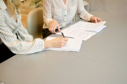 Un incontro tra titolare di PMI e team di un'agenzia di comunicazione che discute un piano di lavoro